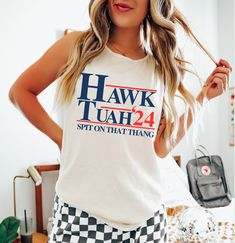 Hawk Tuah 2024 Tee – Vitamin Sea Boutique LLC Cotton Graphic Print Tank Top With Crew Neck, Pre-shrunk Cotton Sleeveless T-shirt, Cotton Graphic Tank Top With Text Print, Casual Tops For 4th Of July With Relaxed Fit, Relaxed Fit Cotton Graphic Tank Top, Casual Relaxed Fit Tops For 4th Of July, Pre-shrunk Cotton Tops For Loungewear, Spring Crew Neck Tank Top With Text Print, Relaxed Fit Graphic Tee Tank Top With Letter Print