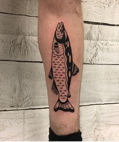 a man's leg with a fish tattoo on it, which is black and white