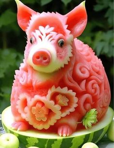 a watermelon carved to look like a pig with flowers and leaves on it