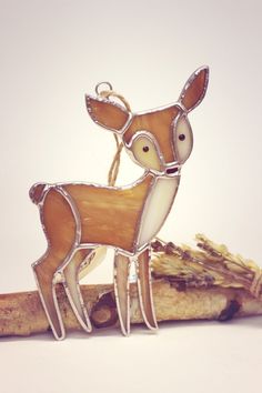 a wooden deer ornament sitting on top of a piece of wood