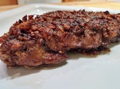 two pieces of meat sitting on top of a white plate