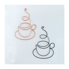 two teacups are sitting next to each other on a white surface, one is orange and the other is black