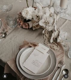 the table is set with flowers and silverware