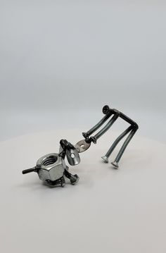 two metal objects sitting on top of a white table next to each other and one is upside down