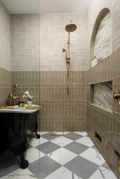 a bathroom with a checkered tile floor and walls, along with a black bathtub