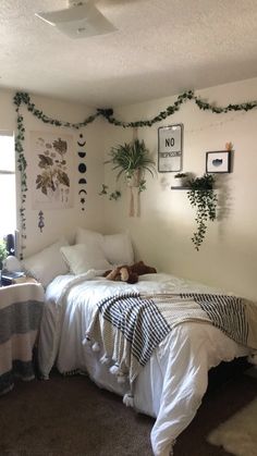 a bedroom with white walls and plants on the wall