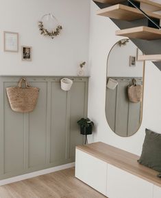 there is a bench with baskets on it and two mirrors hanging above the bench in this room