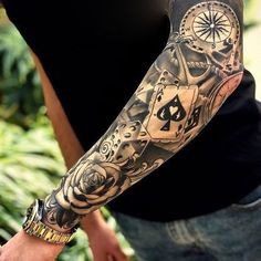 a man with a tattoo on his arm holding a clock and playing cards in front of him