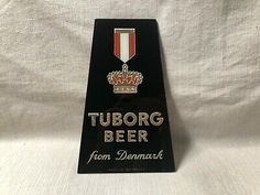 a sign that says tuborog beer from denmark with a crown on the top