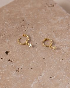 The Gold Star Sleepers are timeless and elegant. This piece in the Celestial collection entails the whimsical wonders of the night sky. Wear with the Starlight Dainty Studs or the Starburst Dainty Studs if you have a second piercing. Size: 18mm, the little star is 3mm Made with 14k gold over S925 silver, tarnish-resistant, hypoallergenic Unfortunately, we are unable to accept returns on earrings due to hygienic reasons. We care about our environment and we hope you do too! Every purchase comes w Tiny Gold Star Cartilage Earrings, Gold Star-shaped Dainty Cartilage Earrings, Gold Star Cartilage Earrings, Gold Star Cartilage Earrings In Minimalist Style, Gold Star Cartilage Earrings Minimalist Style, Gold Dainty Star Cartilage Earrings, Gold Star Cartilage Earrings For Pierced Ears, Dainty Gold Star Cartilage Earrings, Gold Star Charm Hoop Earrings