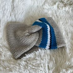 two knitted hats laying on top of a white furnishing covered floor next to each other