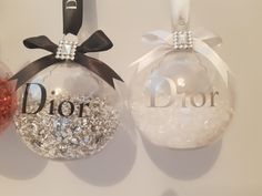 two christmas ornaments with the word dior on one ornament and the other as a decoration