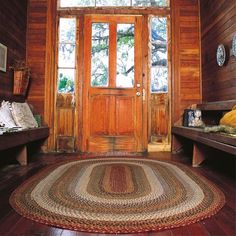 the entryway is decorated with wood paneling and rugs