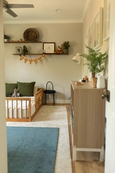 a baby's room with a crib, dresser and shelves on the wall