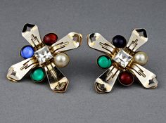 Features: - 100% Authentic MOSCHINO. - Novelty clip earrings representing cross. - Embellished with pearl, red, blue and green glass cabochons. - It used to be gold tone but due to age it became silver, some gold remnants still visible. - Signed MOSCHINO on reverse of one earring. - Good vintage condition. Measurements: Height: 2.28 inches (5.8 cm) Width: 2.28 inches (5.8 cm) Weight per Earring: 16 grams ** These earrings will be shipped via Priority with tracking number. Please convo me for any Vintage Multicolor Evening Earrings, Vintage Multicolor Earrings For Evening, Multicolor Vintage Evening Earrings, Multicolor Vintage Earrings For Evening, Multicolor Clip-on Jewelry For Evening, Multicolor Clip-on Evening Jewelry, Elegant Multicolor Clip-on Earrings, Multicolor Jeweled Clip-on Earrings As A Gift, Novelty Earrings