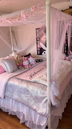 a white canopy bed with pink pillows and teddy bears