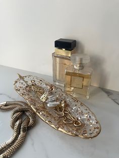 a bottle of perfume sitting on top of a table next to a necklace and snake