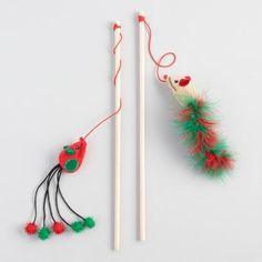 two chopsticks with red and green decorations next to each other on a white surface