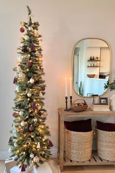 a decorated christmas tree in the corner of a room next to a mirror and stools