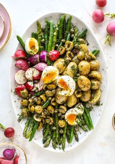 a white plate topped with asparagus and boiled eggs