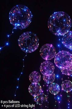 some lights that are glowing up in the dark with balls attached to each other and stringing around them