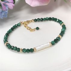 The Èirinn bracelet was inspired by the lush, green landscapes of Ireland. This features AAA, natural malachite with beautiful micro-faceting and rich green color striations. The focal point is a carved, luminous mother of pearl that pairs magically with the malachite. A polished, 14kt gold filled lobster claw clasp and chain finish this piece, and an additional malachite charm adds a pretty accent. Adjustable from approximately 7 to 7.75 inches in length. Please message me if you prefer a short Luxury Malachite Bracelets As A Gift, Malachite Beaded Bracelet As A Gift, Malachite Beaded Bracelets As Gift, Elegant Malachite Beaded Bracelets For Gift, Malachite Bracelet Jewelry Gift, Gift Malachite Beaded Jewelry, Hand-strung Beaded Bracelets For May Birthstone, Elegant Handmade Malachite Bracelets, Hand-strung Beaded Bracelets With May Birthstone