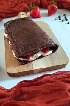 an ice cream sandwich on a cutting board with strawberries