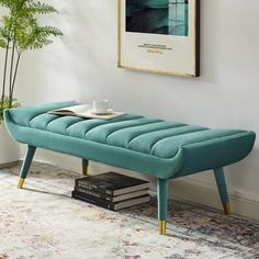 a blue bench sitting on top of a rug in a living room next to a plant