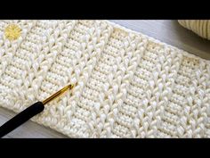 a crocheted blanket with a knitting needle next to it