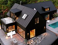 an aerial view of a house with a pool in the yard and decking area