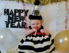 a baby wearing a black and white striped dress with a party hat on it's head