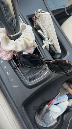 sunglasses and other items are sitting in the center console of a car