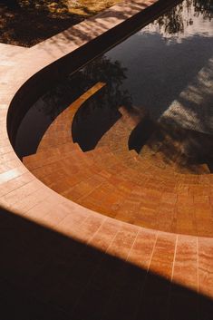 the shadow of a bench on top of a pool