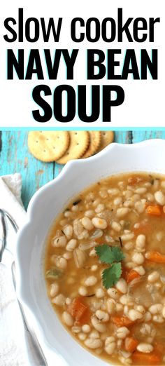 a white bowl filled with soup next to crackers on a blue wooden table and text overlay reads slow cooker navy bean soup