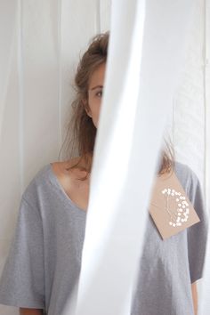 a woman standing in front of a white curtain