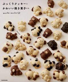 there are many small brown and white teddy bears on the table with words written in japanese