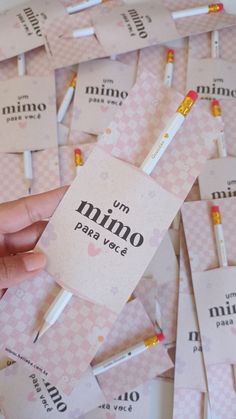 a hand is holding a pack of minio pens in front of many small ones