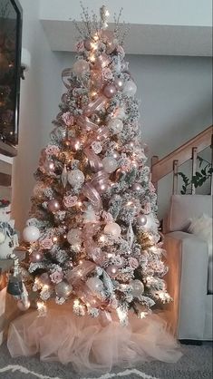 a white christmas tree with pink and silver ornaments