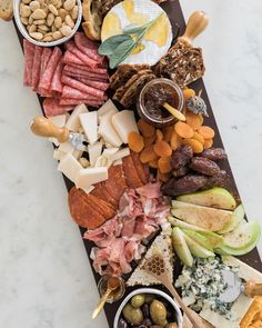 an assortment of cheeses, crackers, and meats on a platter