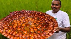 a man holding a large tray full of hotdogs in the middle of a field