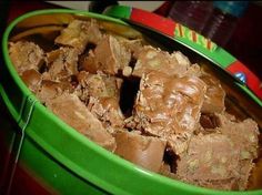 a green bowl filled with brownies sitting on top of a table