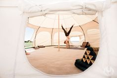 a person doing a handstand in a tent