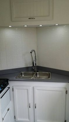 a kitchen with white cabinets and black counter tops