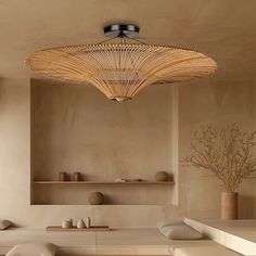 a large bamboo light fixture hanging from the ceiling in a room with white walls and flooring