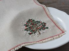 a white plate topped with a christmas tree on top of a wooden table next to a napkin