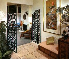 a living room filled with lots of furniture and art on the wall next to a doorway