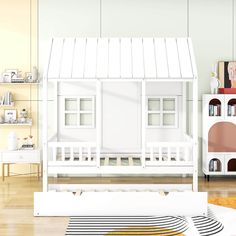 a white doll house sitting on top of a wooden floor next to a book shelf