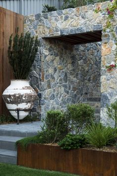 an outdoor area with stone walls and plants