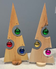 three wooden christmas trees with ornaments on them