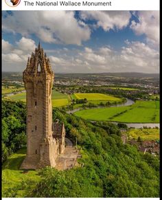 an aerial view of a tall tower in the middle of a lush green field and river